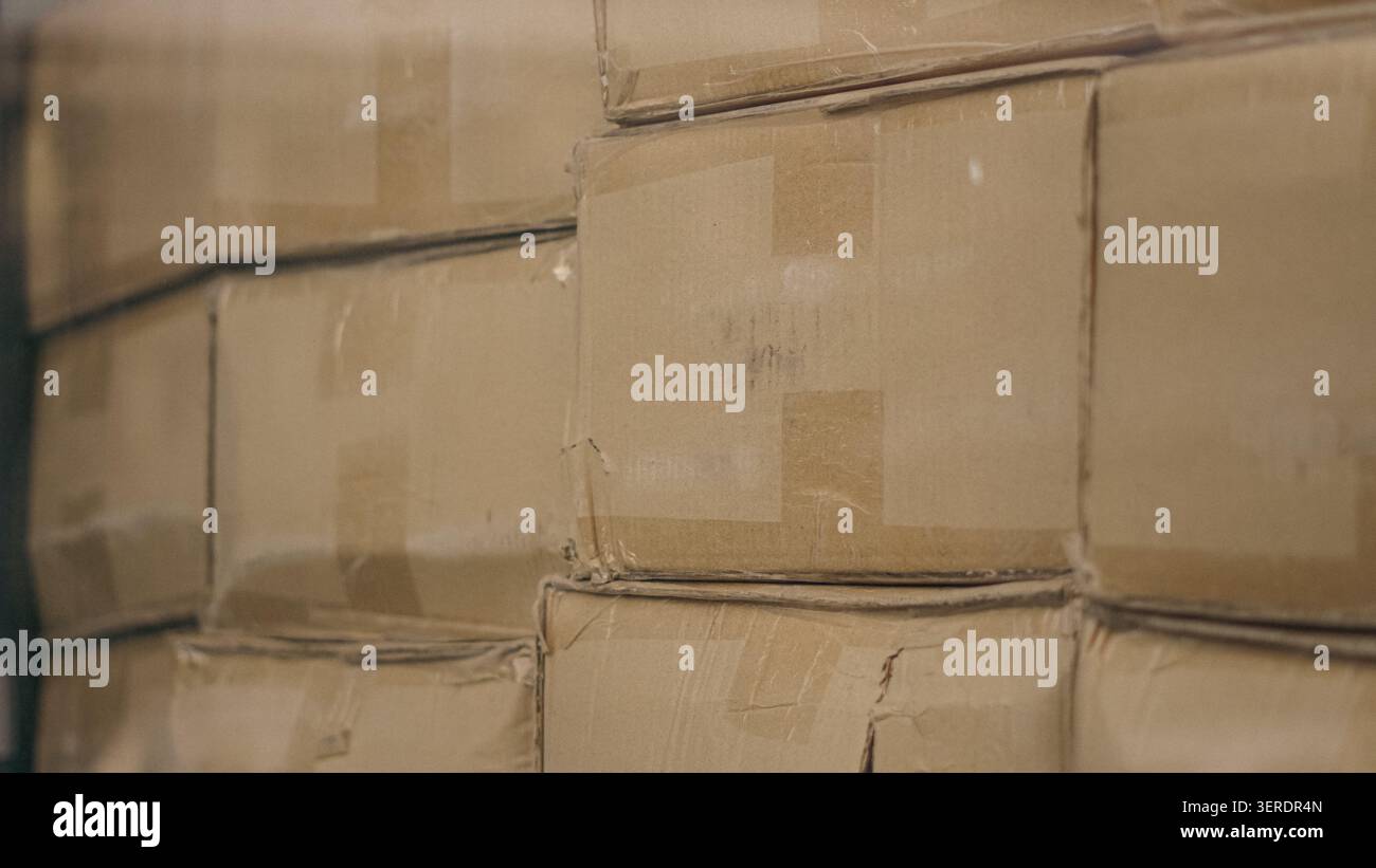Cardboard boxes stacked inside distribution warehouse close up. Stock Photo