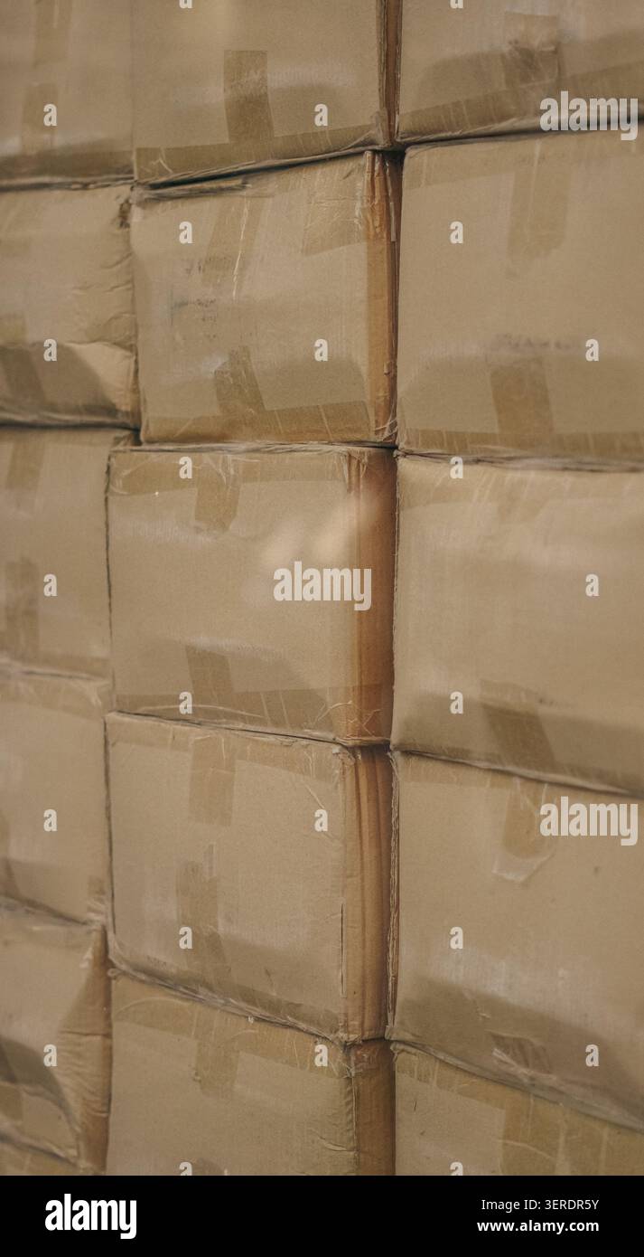 Cardboard boxes stacked inside warehouse behind reflection window close up. Stock Photo