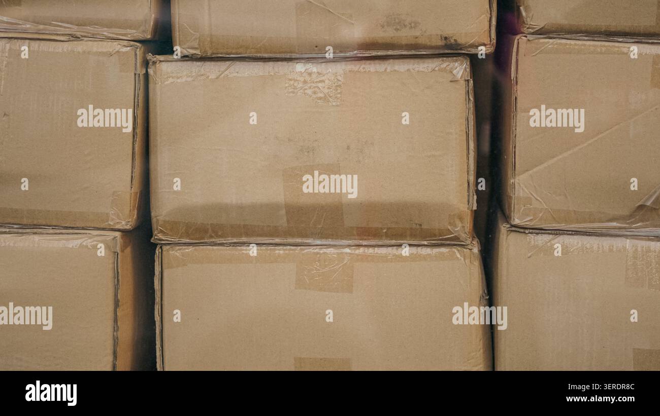 Cardboard boxes stacked in a warehouse closeup. Stock Photo