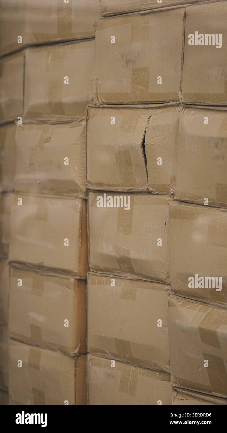 Cardboard boxes stacked inside distribution warehouse close up. Stock Photo