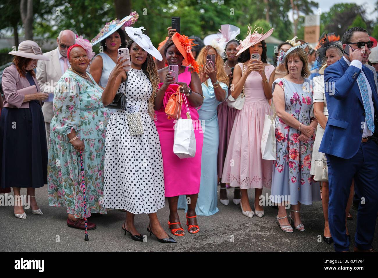 Racegoers take pictures of the media as they arrive on the third day of ...