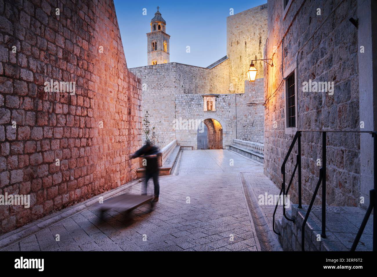 Dubrovnik, Croatia with a lone figure pushing a cart through Ploce Gate in the early morning. Stock Photo