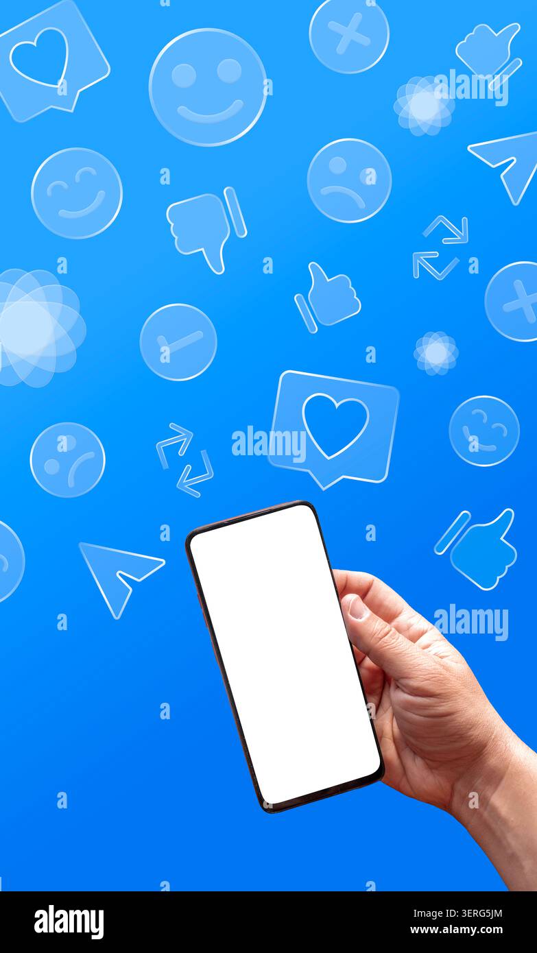 Hand holding smartphone with blank screen, social media icons floating on a blue background Stock Photo