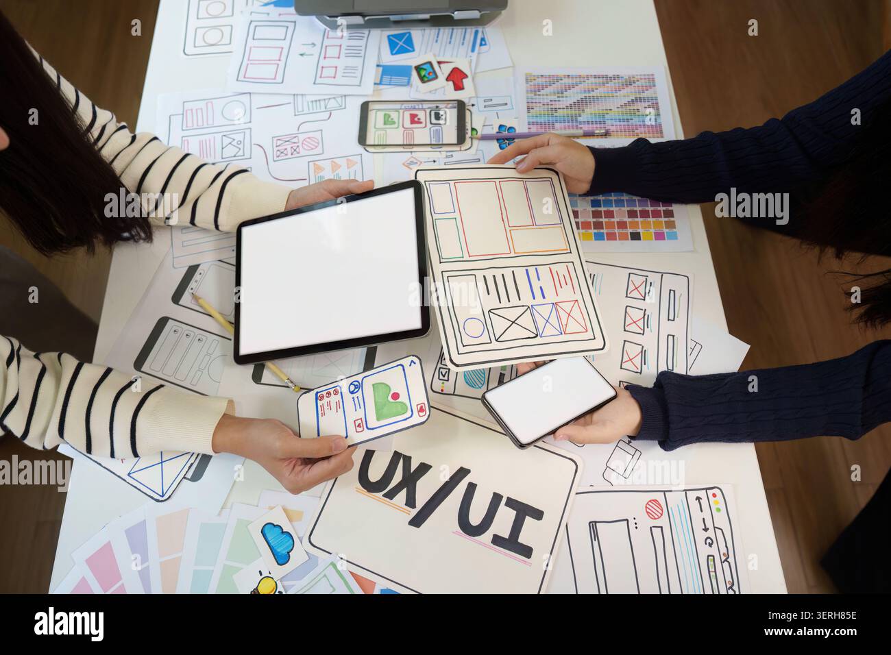UX UI designers collaborating on mobile app wireframe and user interface design Stock Photo