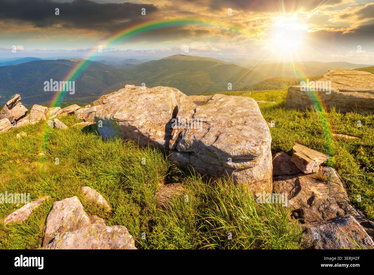 sunset over mountain landscape with grass and rock on a slope. view in to the distant valley of carpathian mountains. mountainous scenery of ukraine i Stock Photo