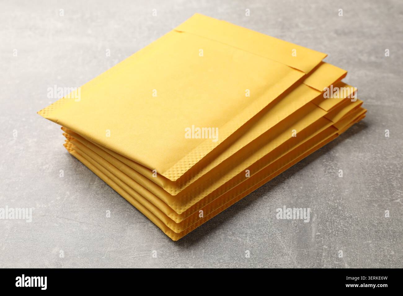 Stack of yellow envelopes on grey table, closeup Stock Photo