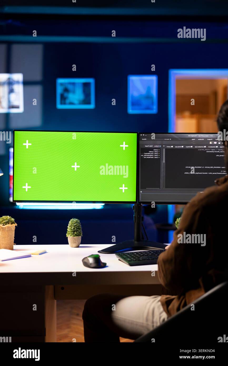 Programmer using green screen computer to secure company servers from virus attacks. IT remote employee writing code, building firewalls protecting data using mockup PC monitor. Stock Photo