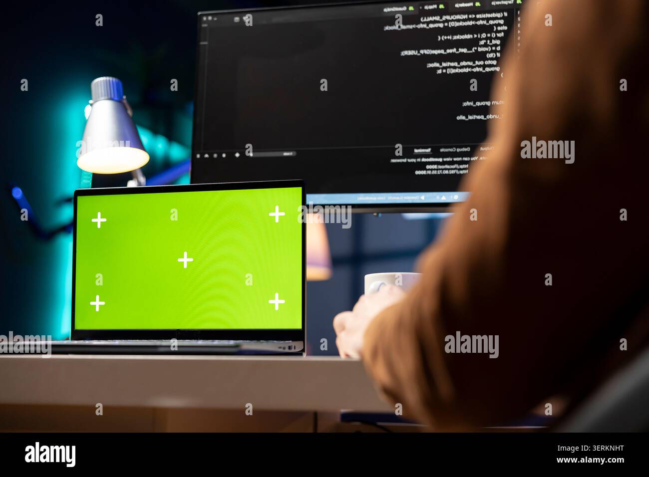 Man working from home using isolated screen laptop, testing and deploying programs and systems. Programmer checking code displayed on computer monitors using chroma key notebook. Stock Photo