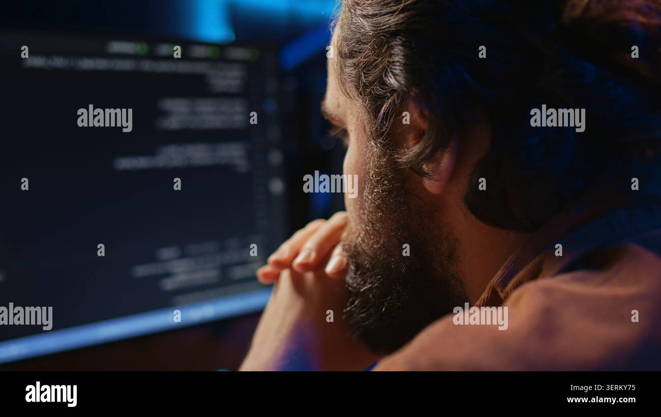 Programmer in home office concentrating on finding bugs while doing coding on computer, extreme close-up shot, iT admin frowning while looking at screen, confused by errors in lines of code. Stock Photo