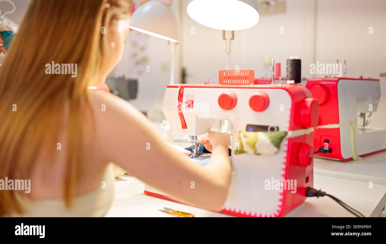 Woman working with sewing machine in craft workshop Stock Photo