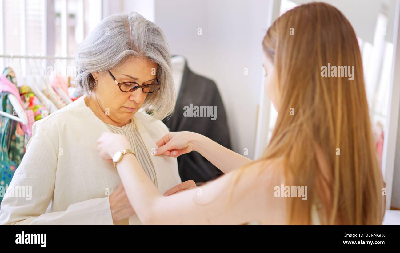 Designer adjusting clothing on a client Stock Photo