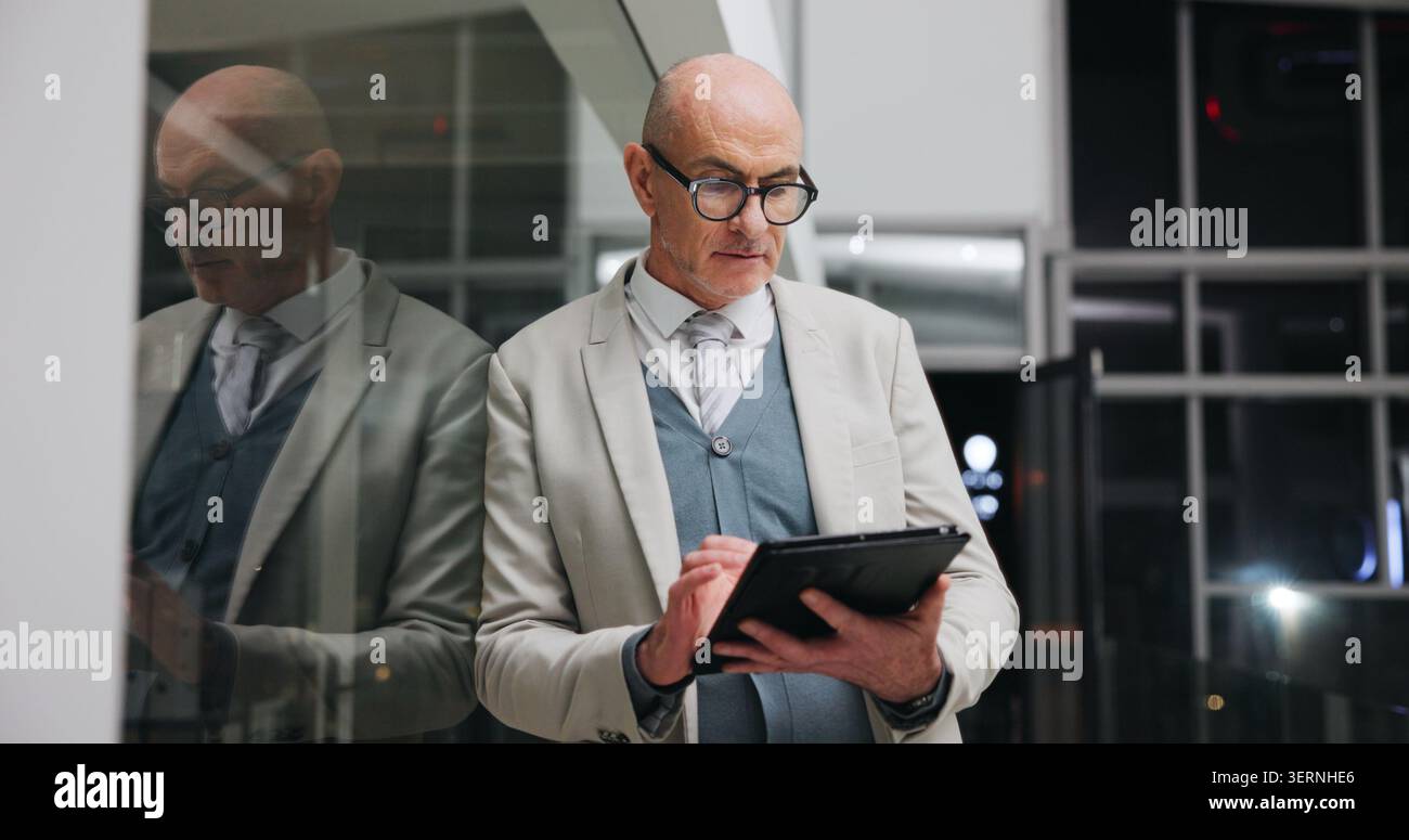 Businessman, scroll and research on tablet at night, investment banking and project deadline on web. Mature person, working late and business analyst Stock Photo