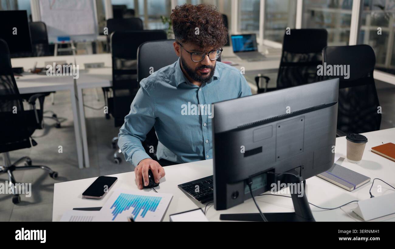 Arabian business man using computer network typing desktop application developing coding programmer ethnic businessman working in office at table male Stock Photo