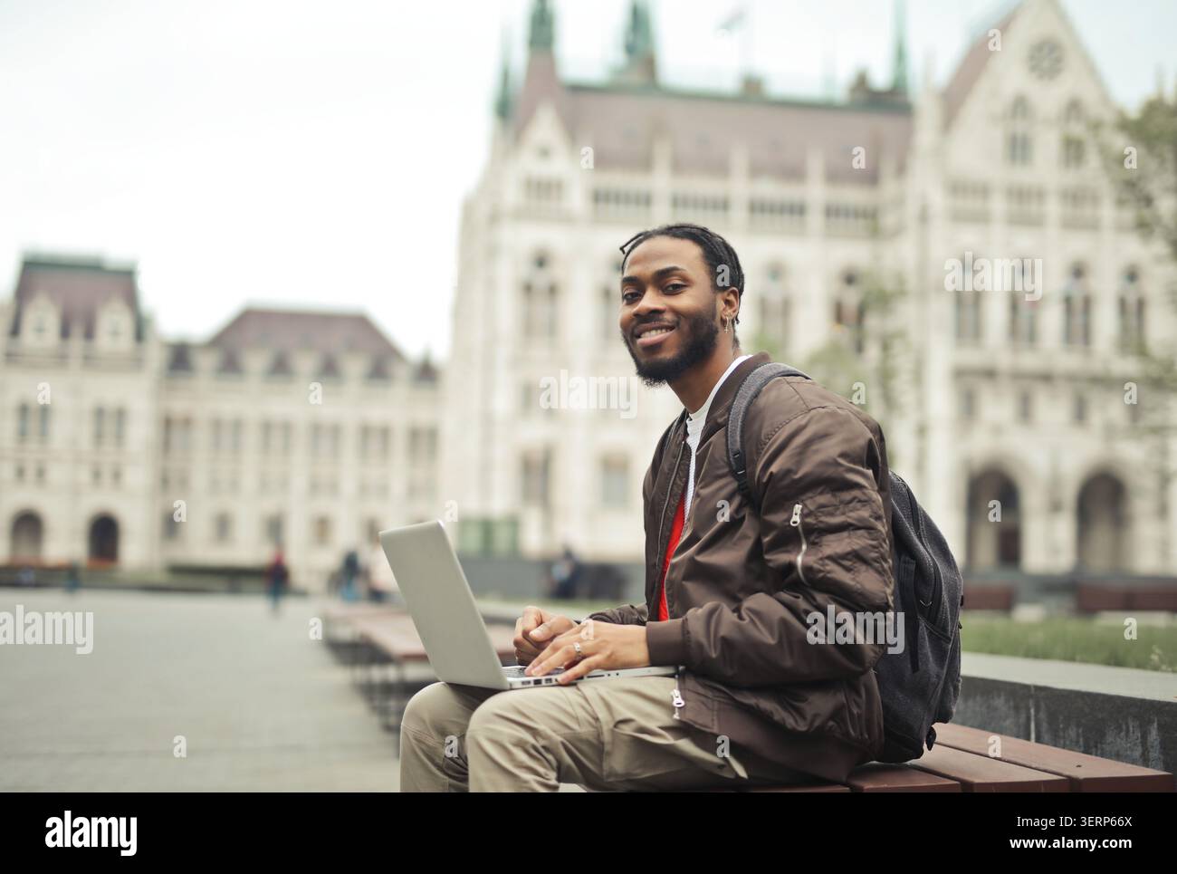 Happy man using laptop outdoors in Budapest Stock Photo