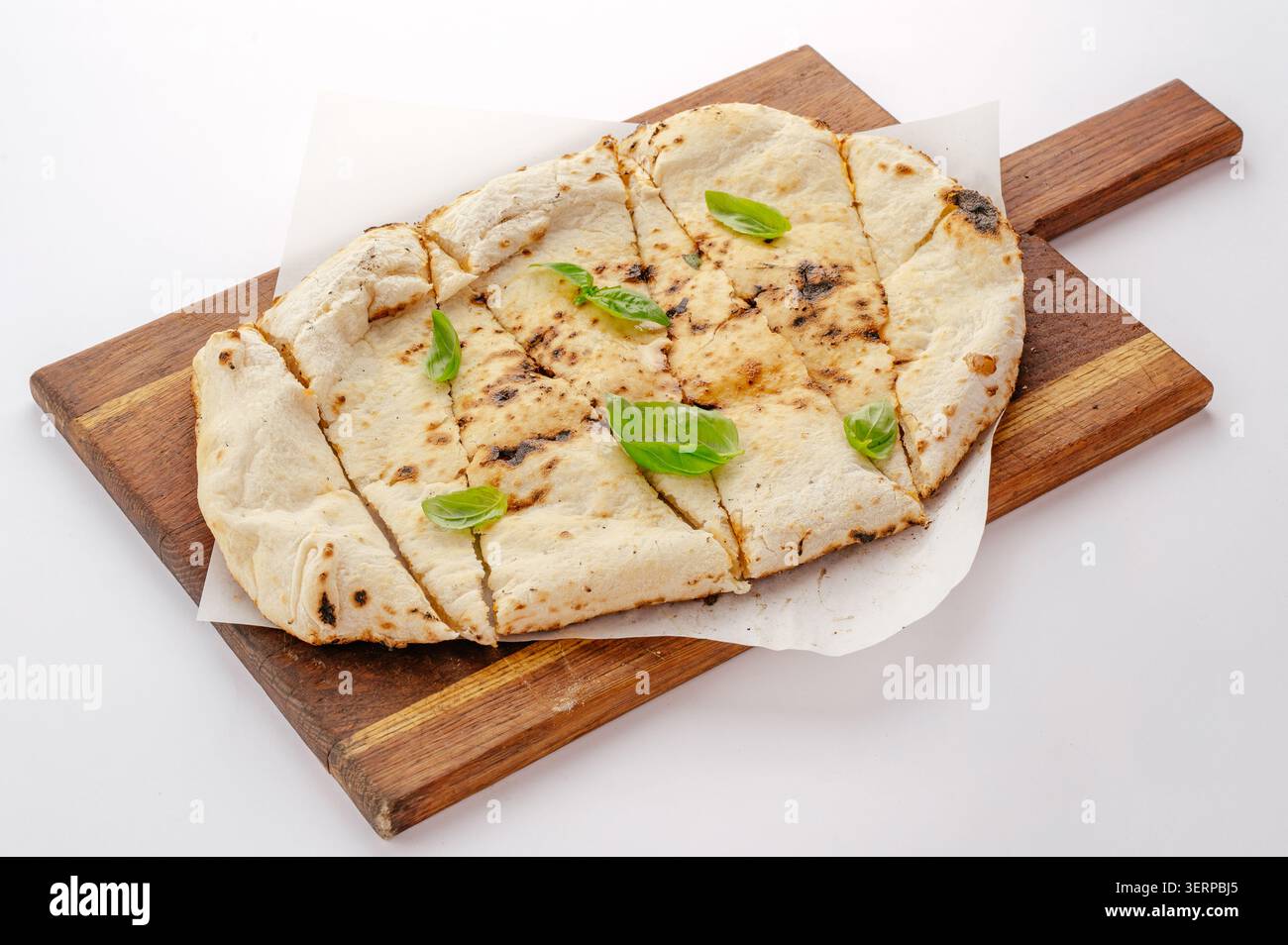 Freshly baked flatbread sliced and served with basil Stock Photo