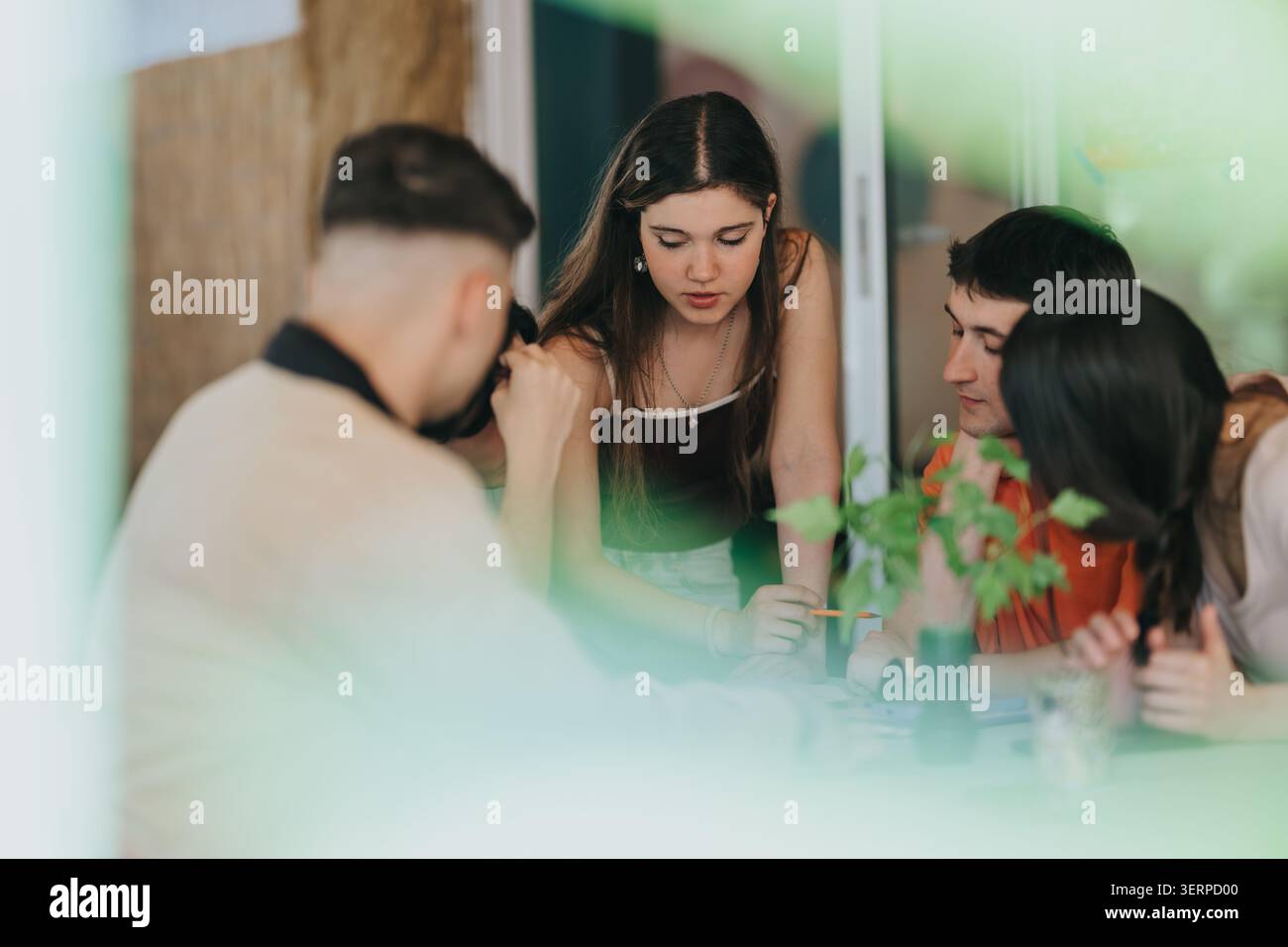 High school students collaborating on a school project around a table in a casual study session Stock Photo