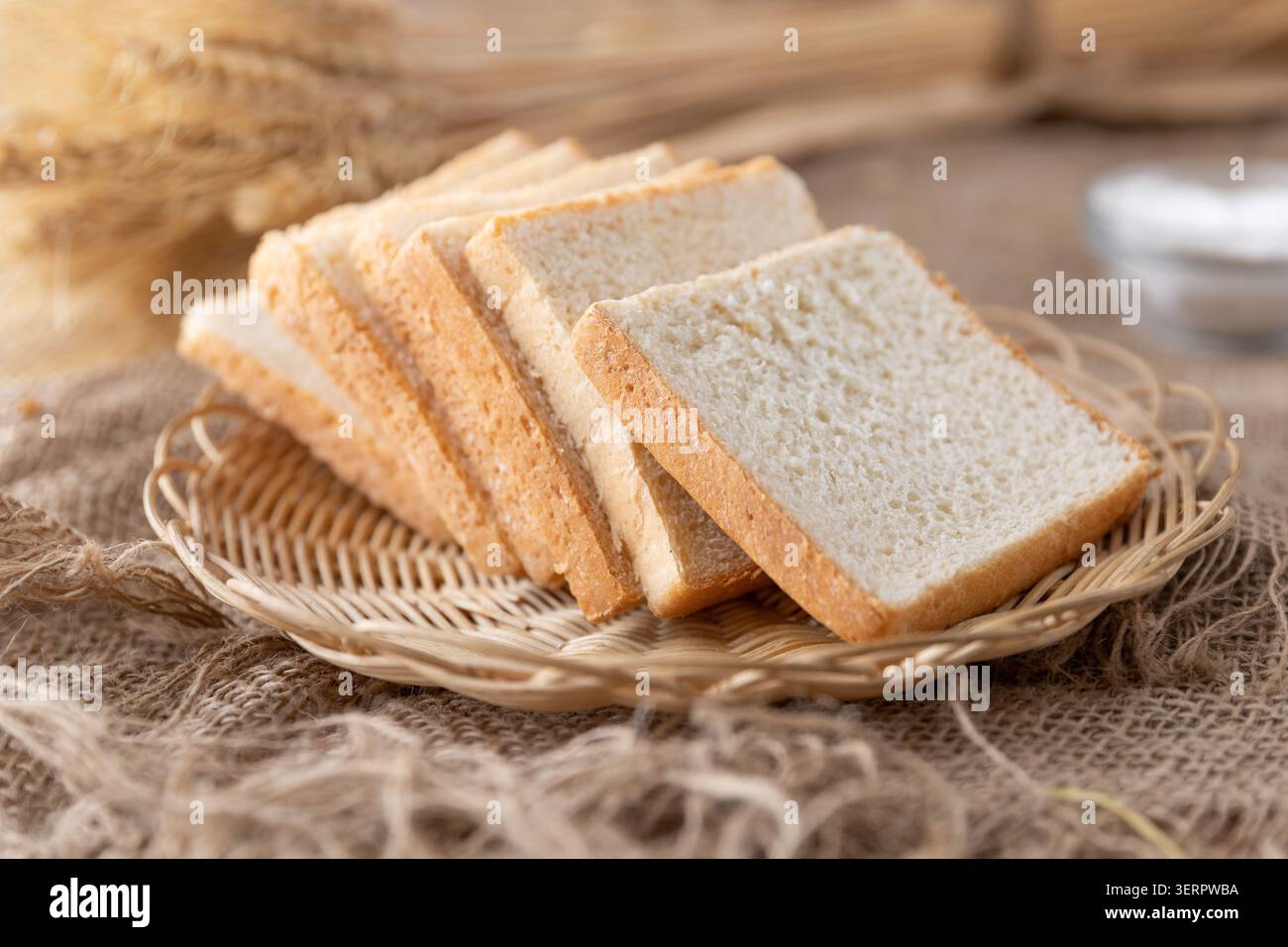 Fresh Sliced White Sandwich Bread on Wicker Basket with Rustic Kitchen Background Stock Photo