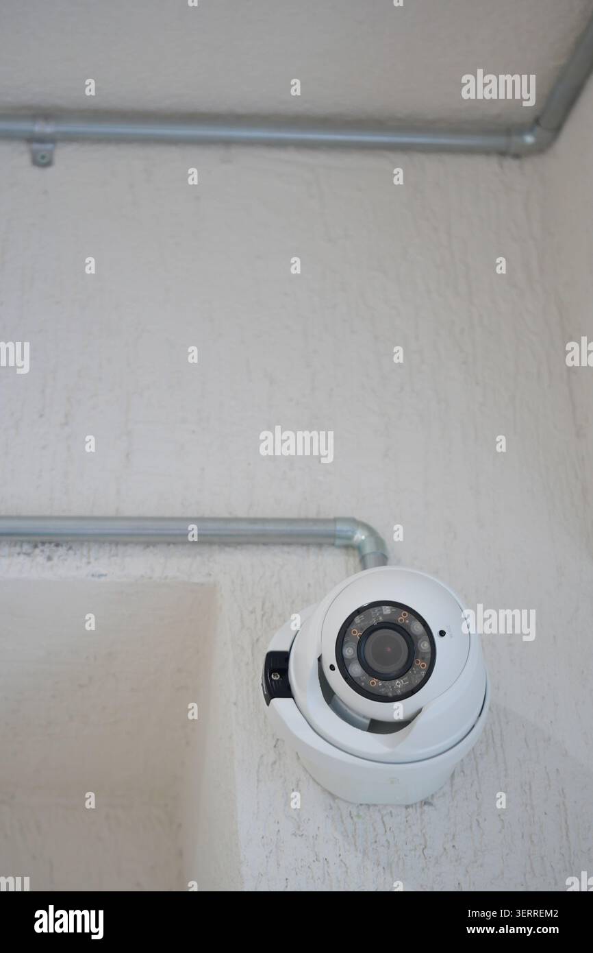 Security camera mounted on wall in indoor area Stock Photo