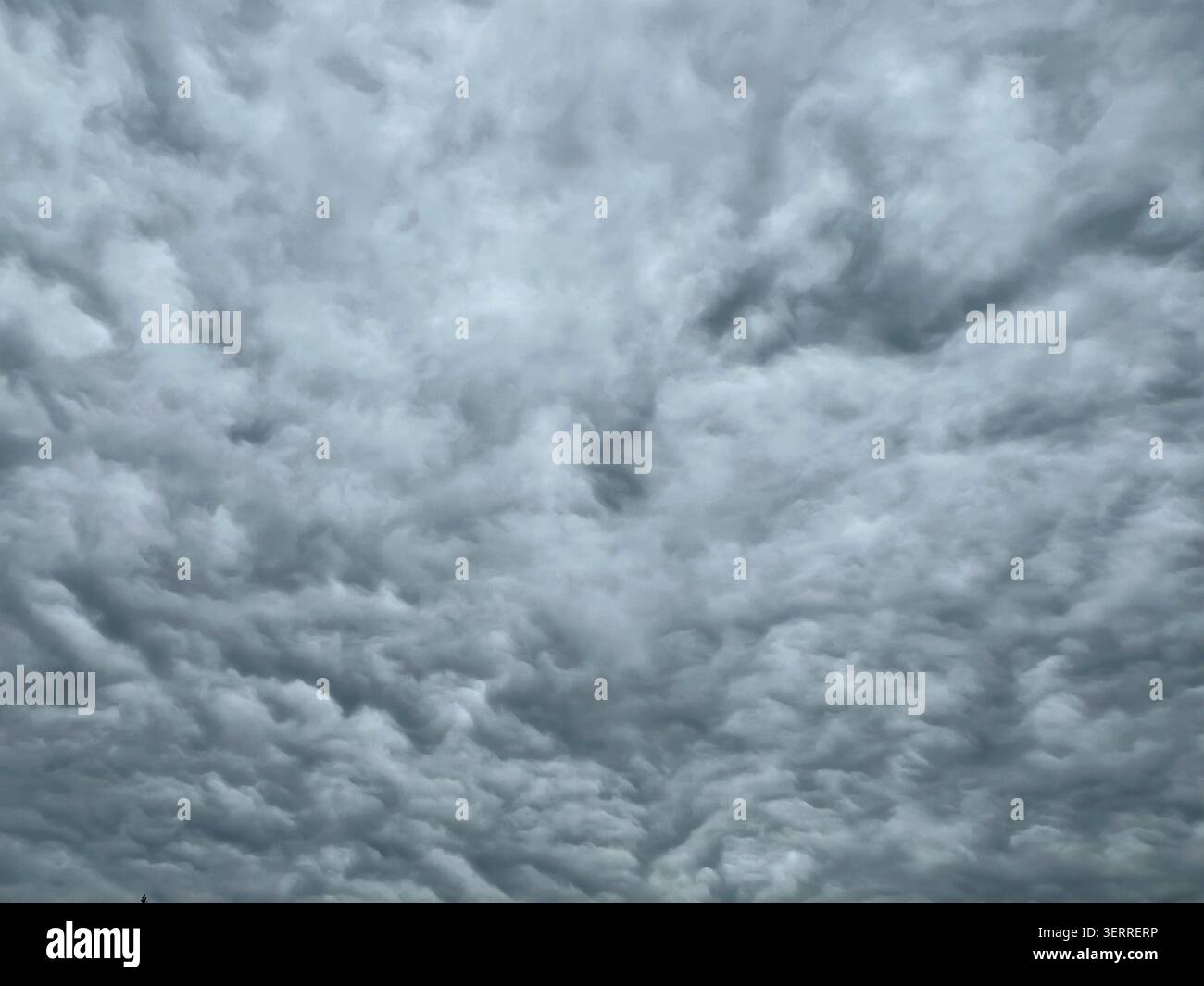 Full frame overcast sky filled with dense layered grey clouds on a cloudy day Stock Photo