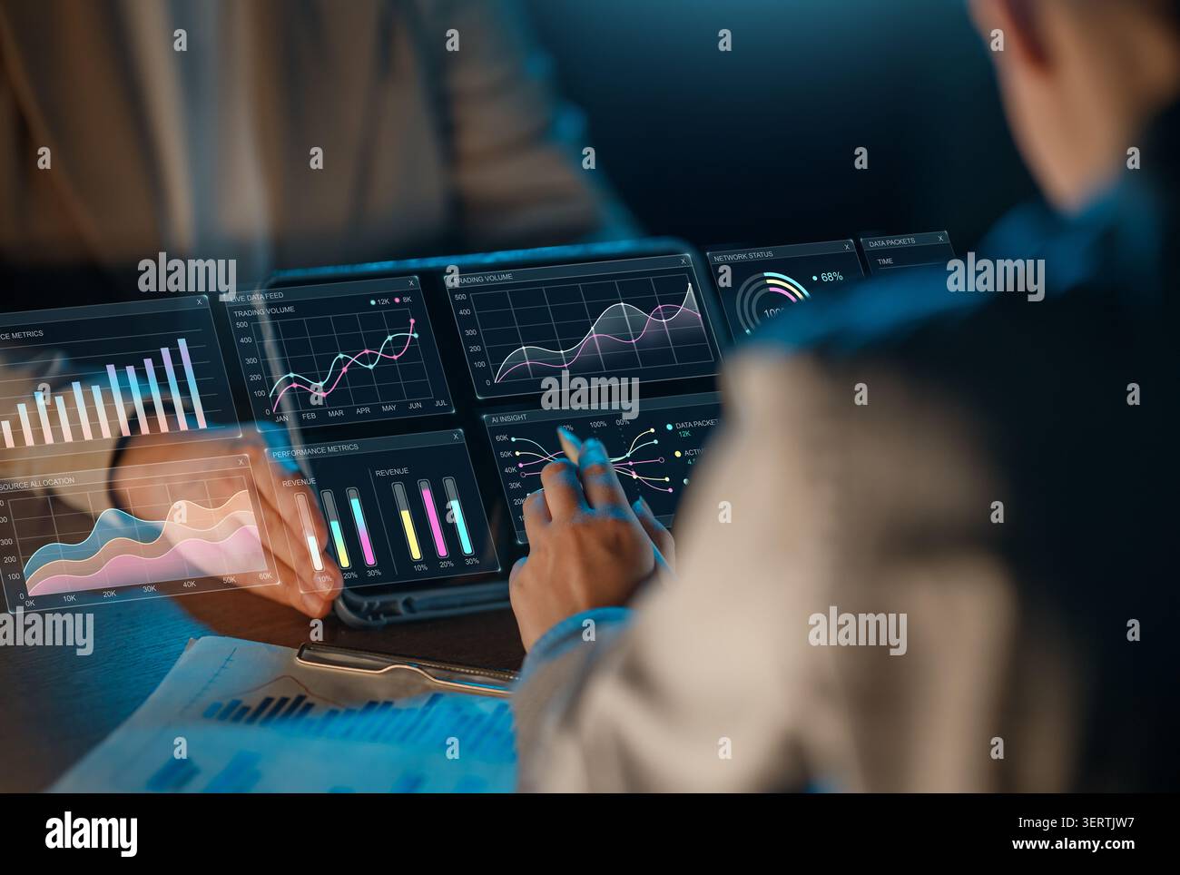 Dynamic image capturing professionals collaborating over futuristic digital interfaces displaying interactive financial graphs, business analytics, an Stock Photo