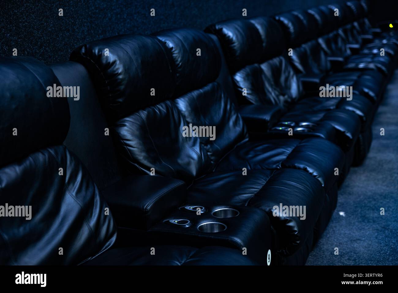 Empty dark rows of blue cinema seats in auditorium Stock Photo