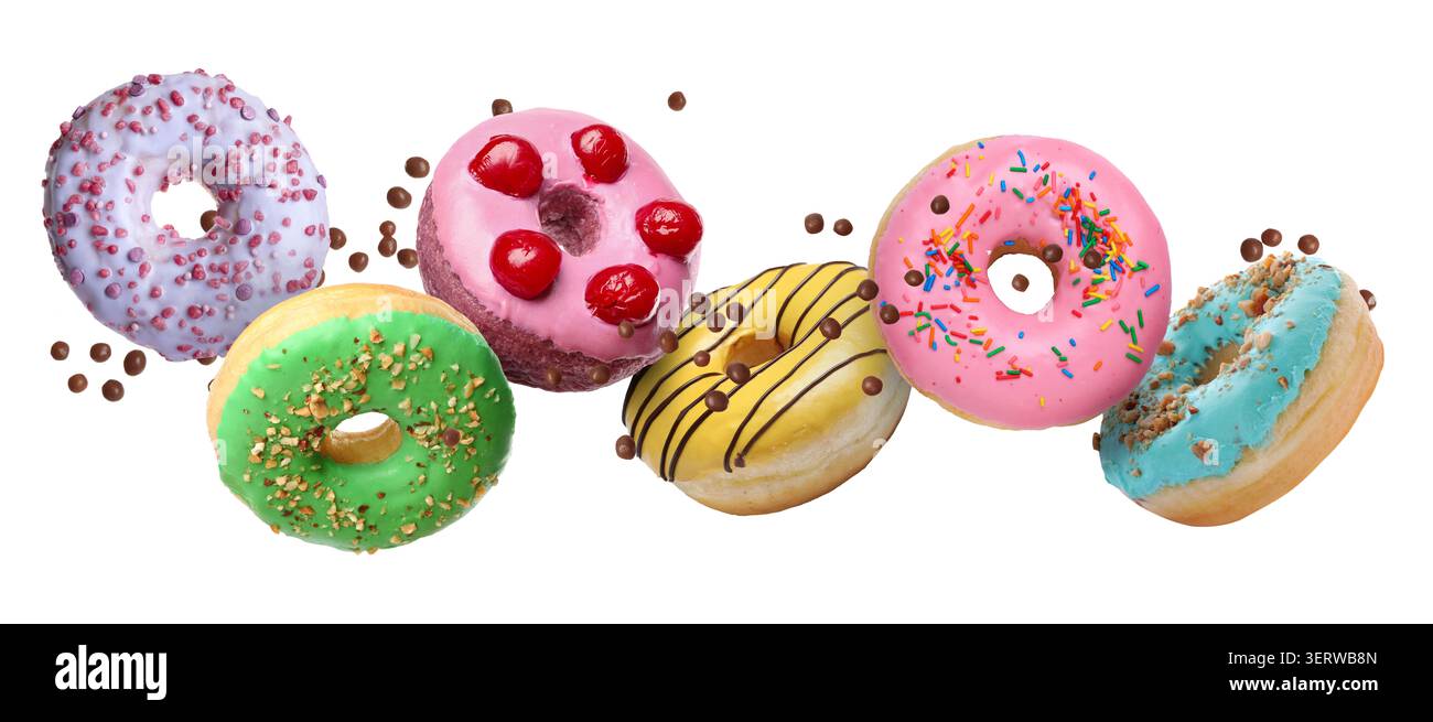 Sweet donuts and sprinkles falling on white background Stock Photo