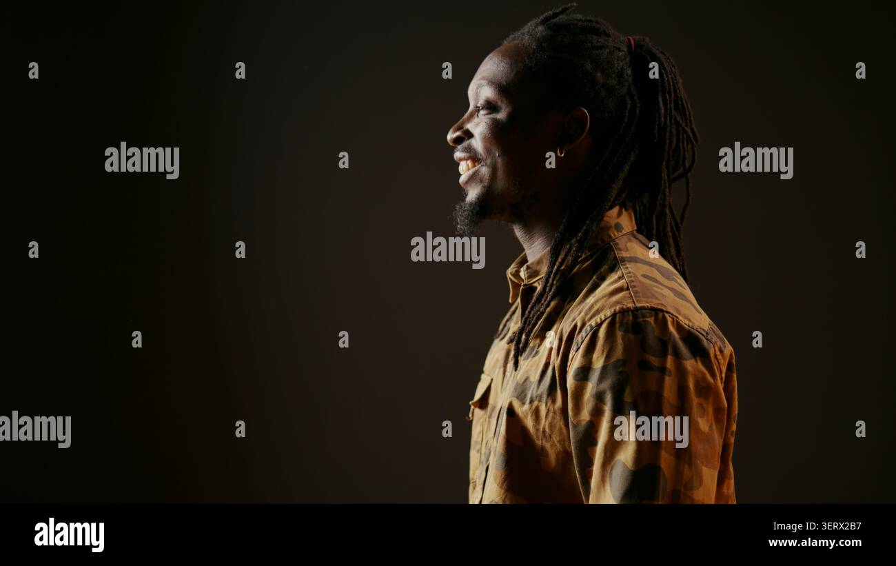 African American man having fun in black studio, laughing at jokes with his friends and enjoying good vibes on camera, young person feeling happy and laughs at funny memes, handheld shot. Stock Photo