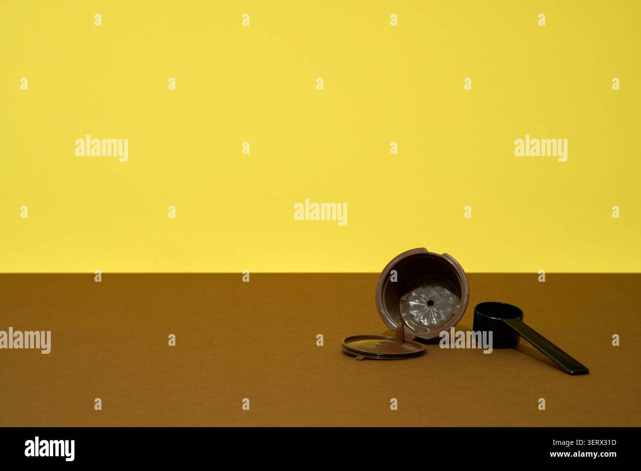 Reusable coffee capsule on brown table with yellow background Stock Photo