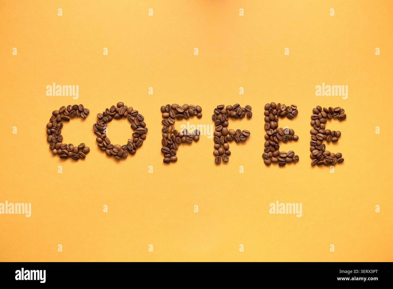 "Coffee" Written with Beans on a Yellow Background Stock Photo