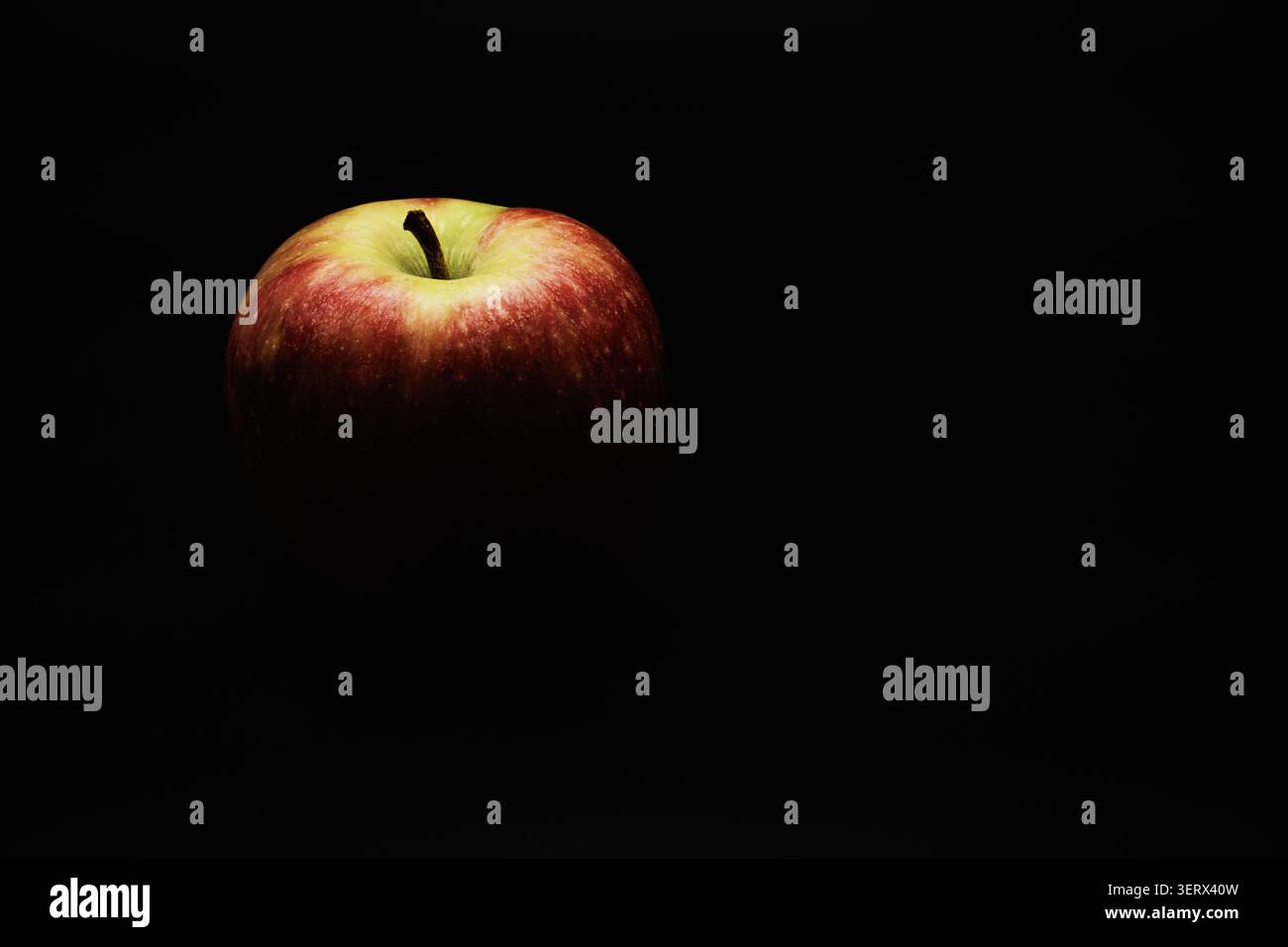 An apple fading in black. Stock Photo
