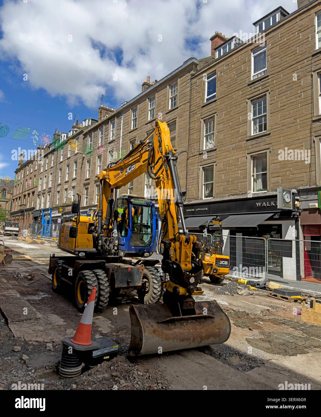 Roadworks with excavator and construction equipment on a Dundee city street in Scotland, UK. Stock Photo