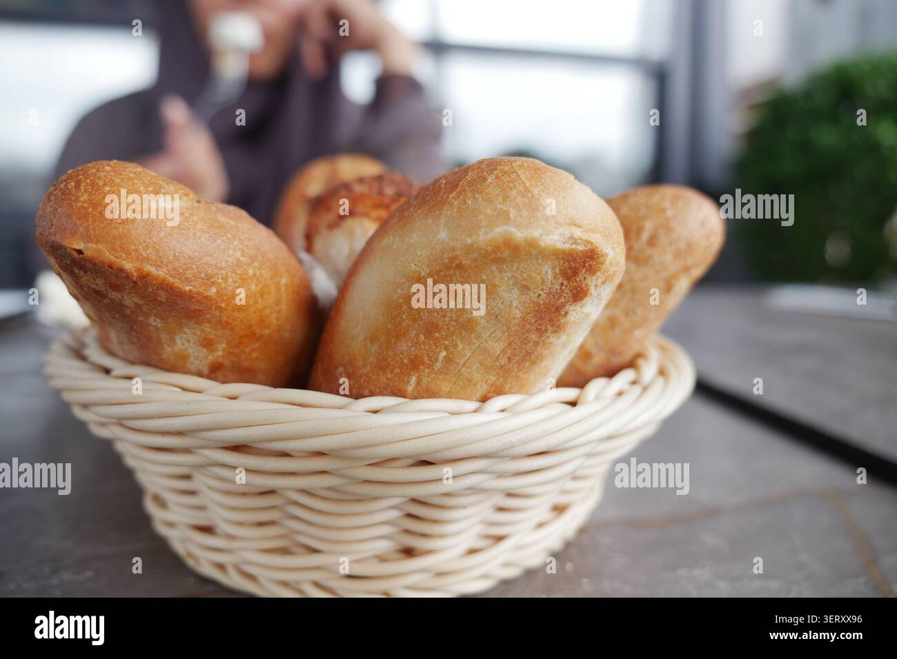 Fresh bread rolls in a basket on a table Stock Photo