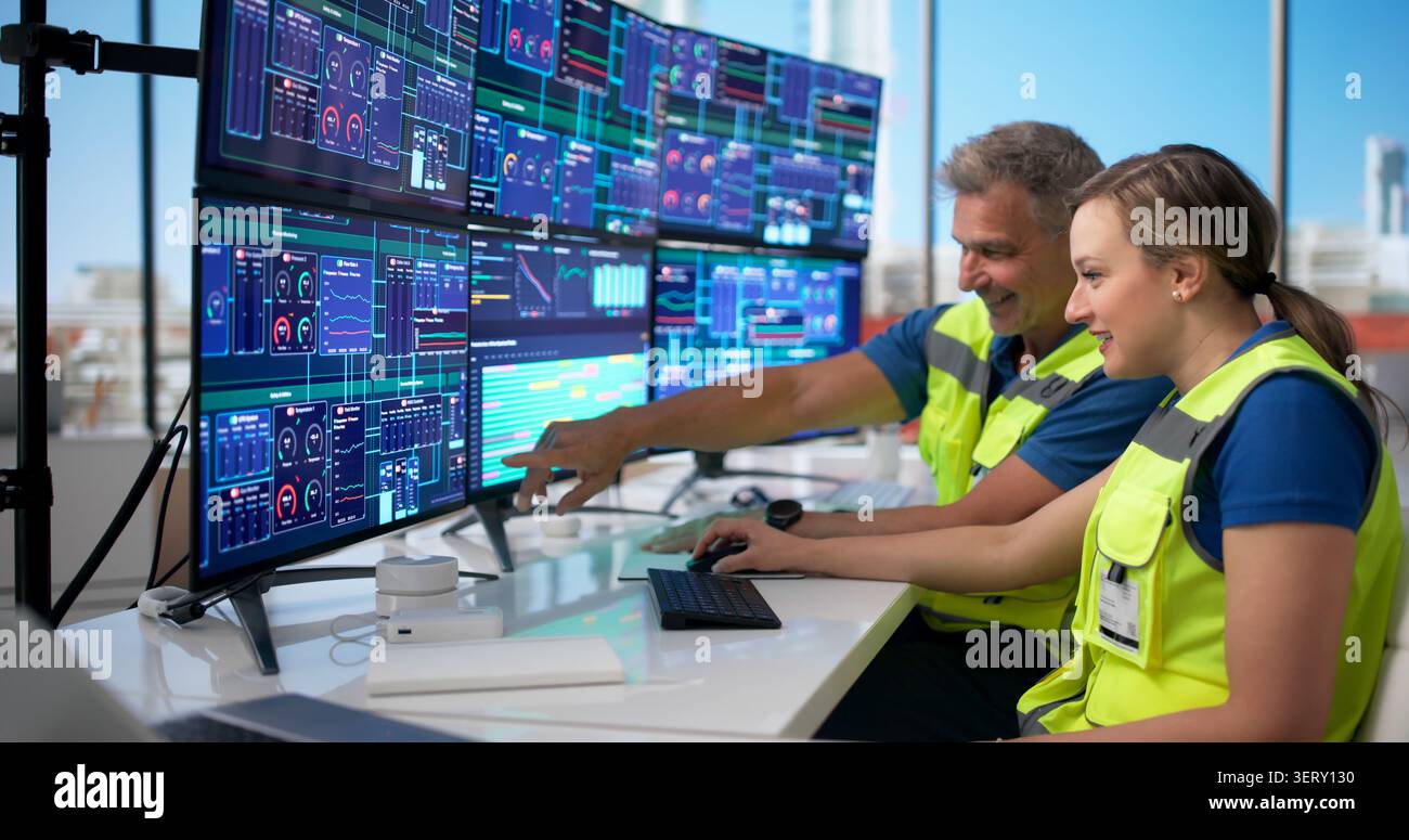 Two Engineers Monitor Industrial Gas Plant Systems Using Advanced Computer Controls. Stock Photo