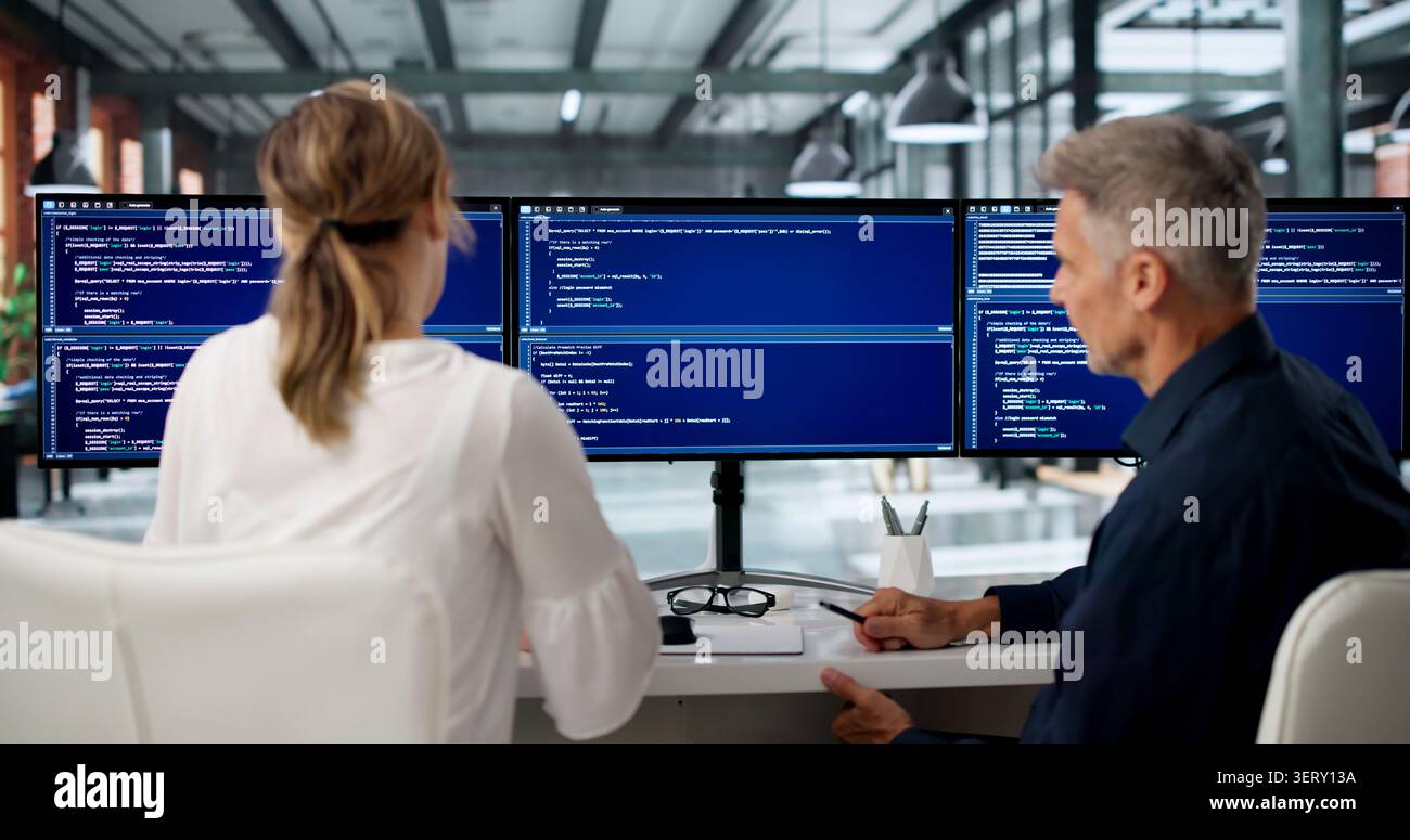 Two Software Engineers Discuss Coding Ideas While Working Together. Stock Photo