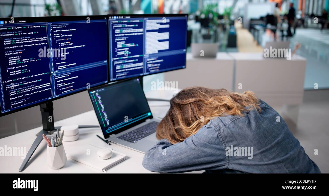 Frustrated Woman Programmer Struggles With Coding Errors Late In Office. Stock Photo