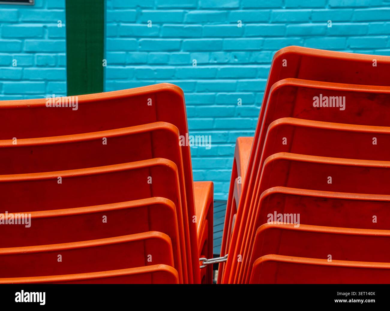 Red plastic stackable chairs on a restaurant patio Stock Photo