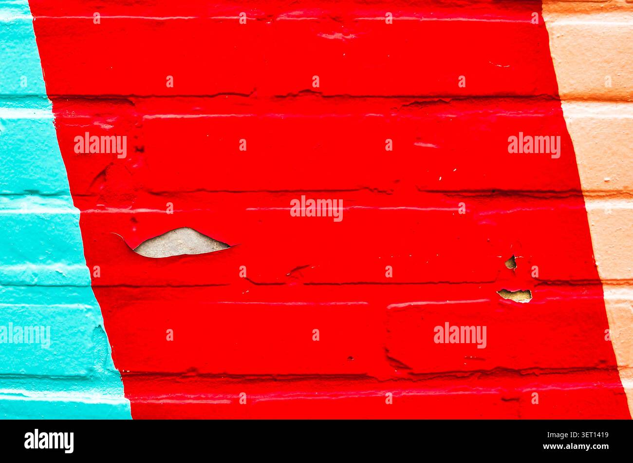 A textured brick wall with peeling paint Stock Photo