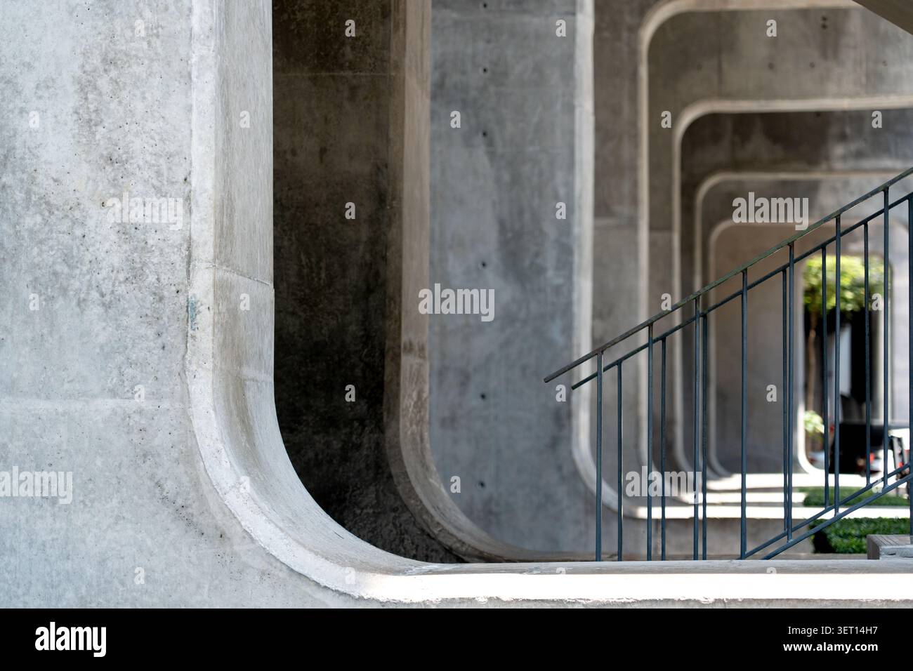 A striking shot of raw concrete brutalist architecture featuring a perspective view of repeating rounded rectangular arches. The composition includes Stock Photo