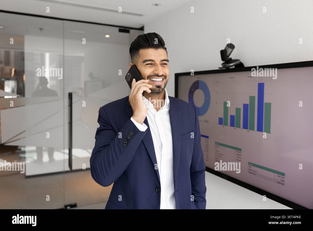 Confident businessman talking on phone in office Stock Photo