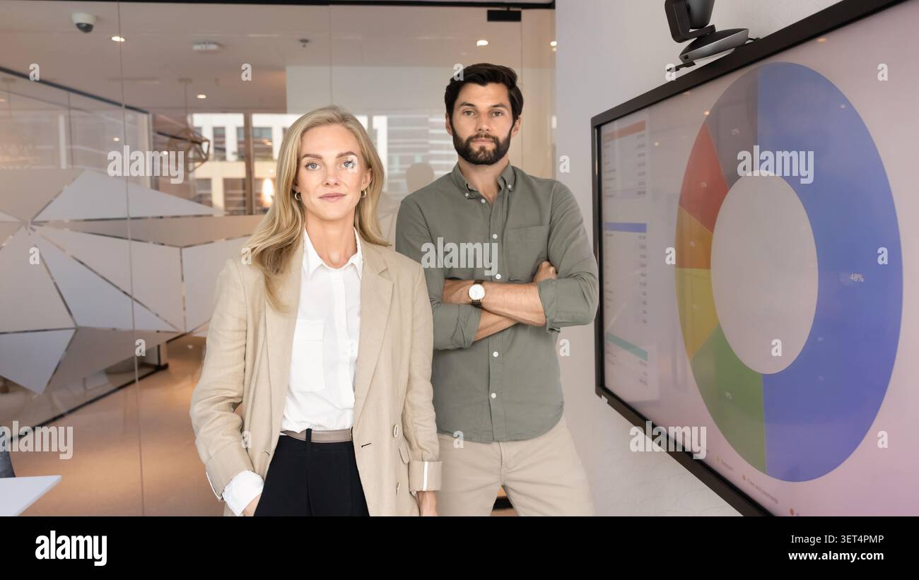 Trainers or project coordinators standing next to screen showing chart Stock Photo