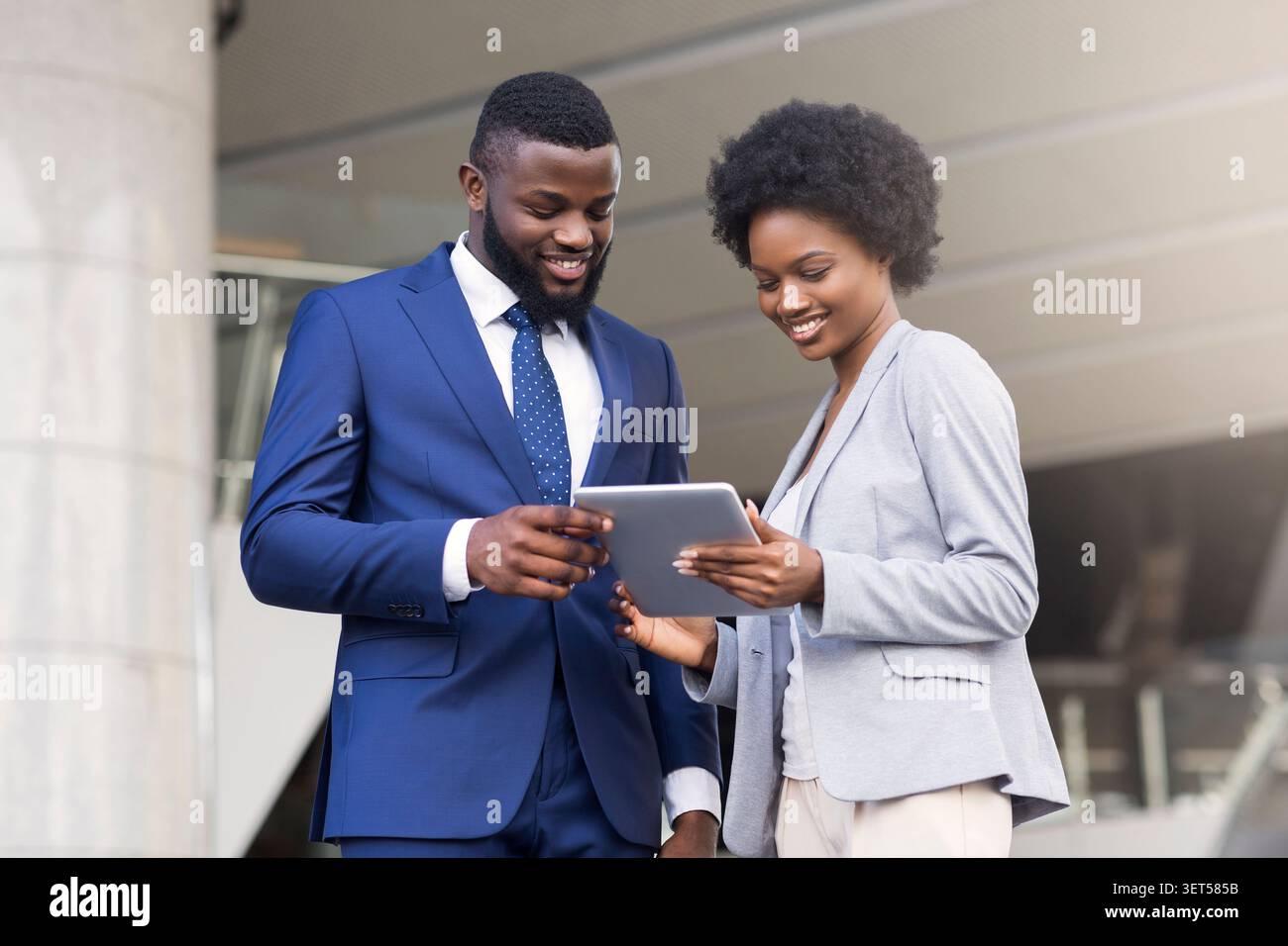 Business people using digital tablet and discussing new project outdoors Stock Photo