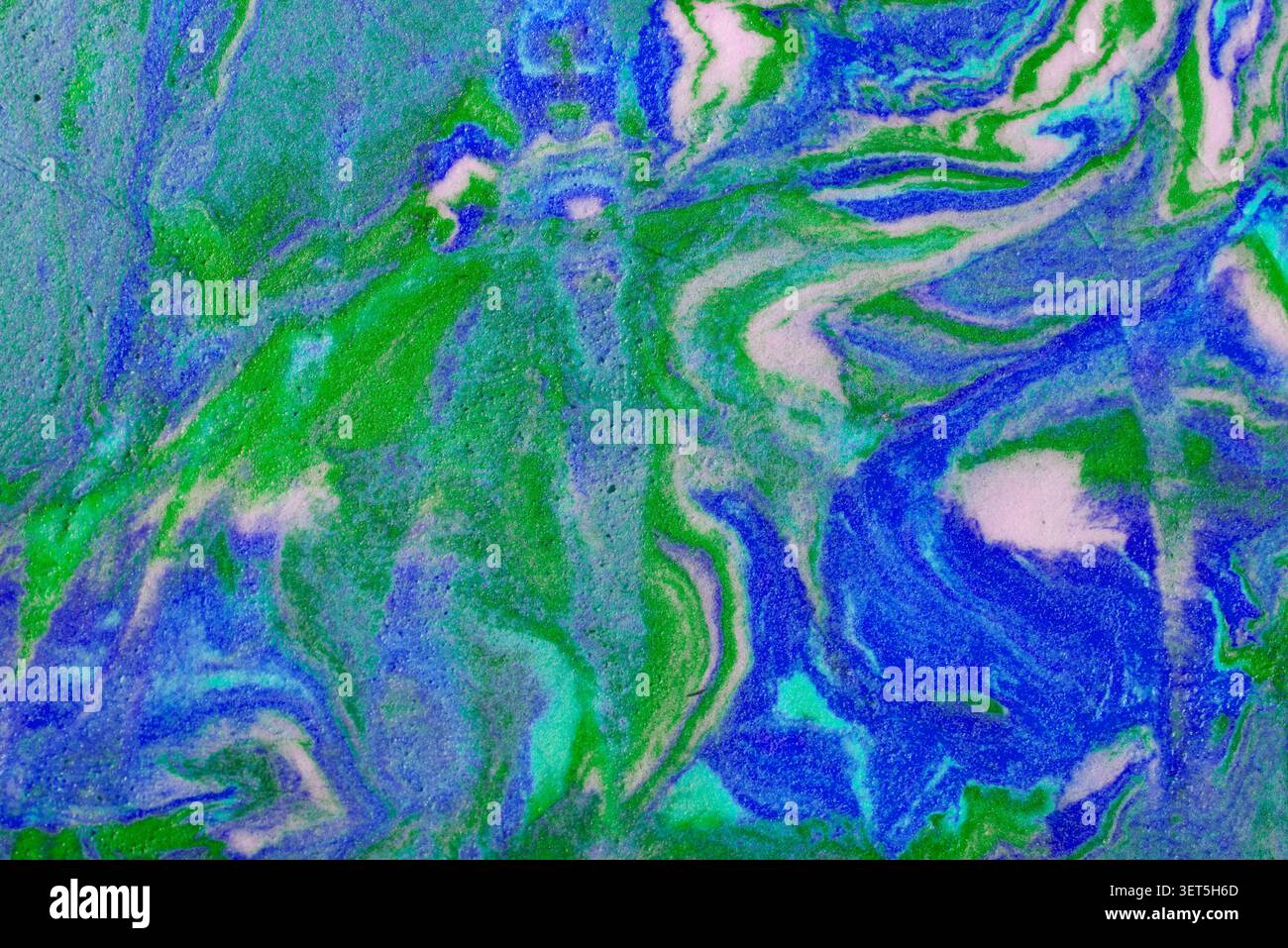 Fluid paint creating an abstract swirled texture and pattern Stock Photo