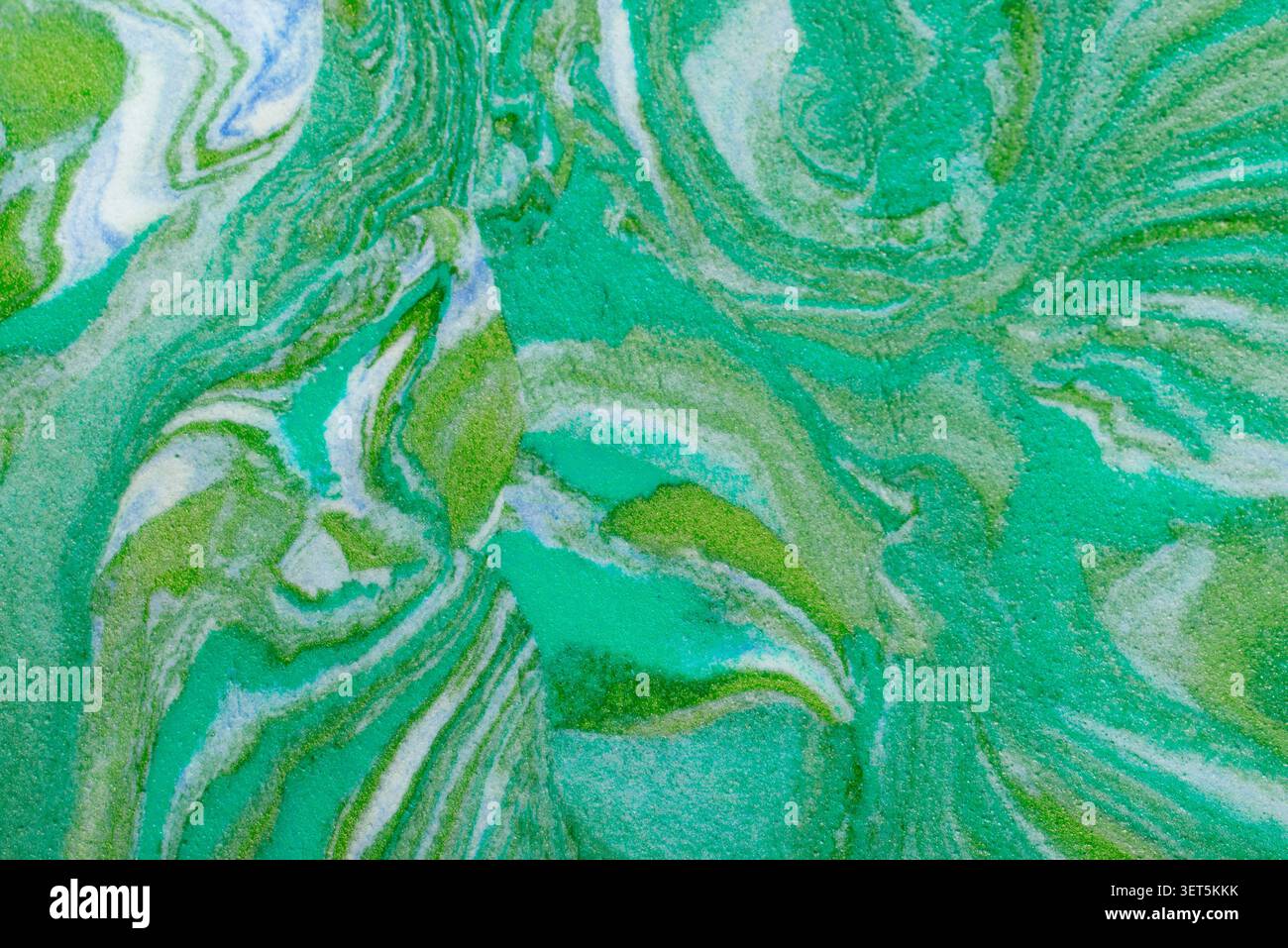 Abstract green and blue paint swirling, creating a marbling texture and pattern Stock Photo