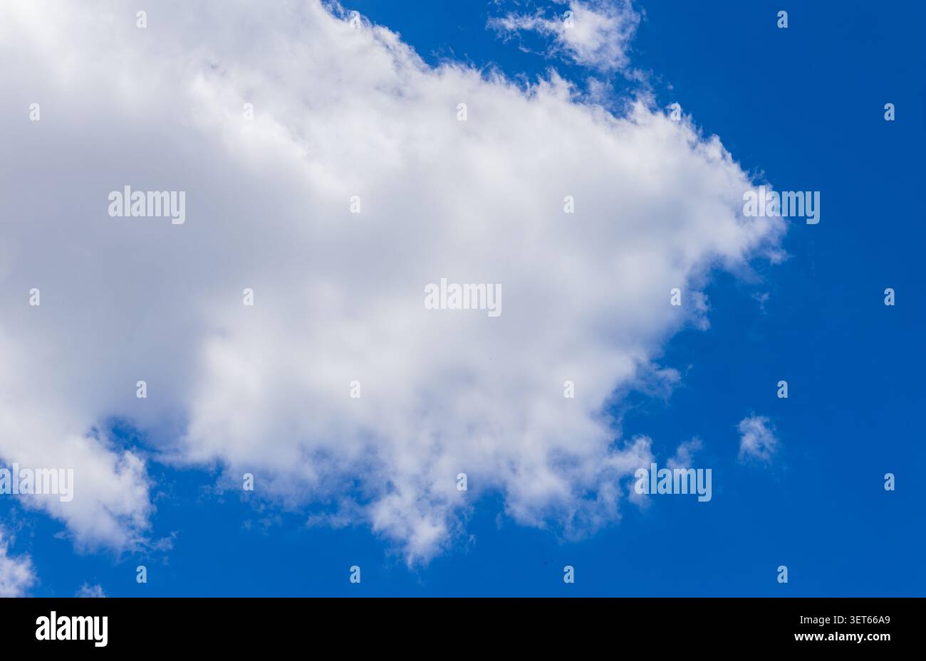 Large white cloud floating in a deep blue summer sky Stock Photo