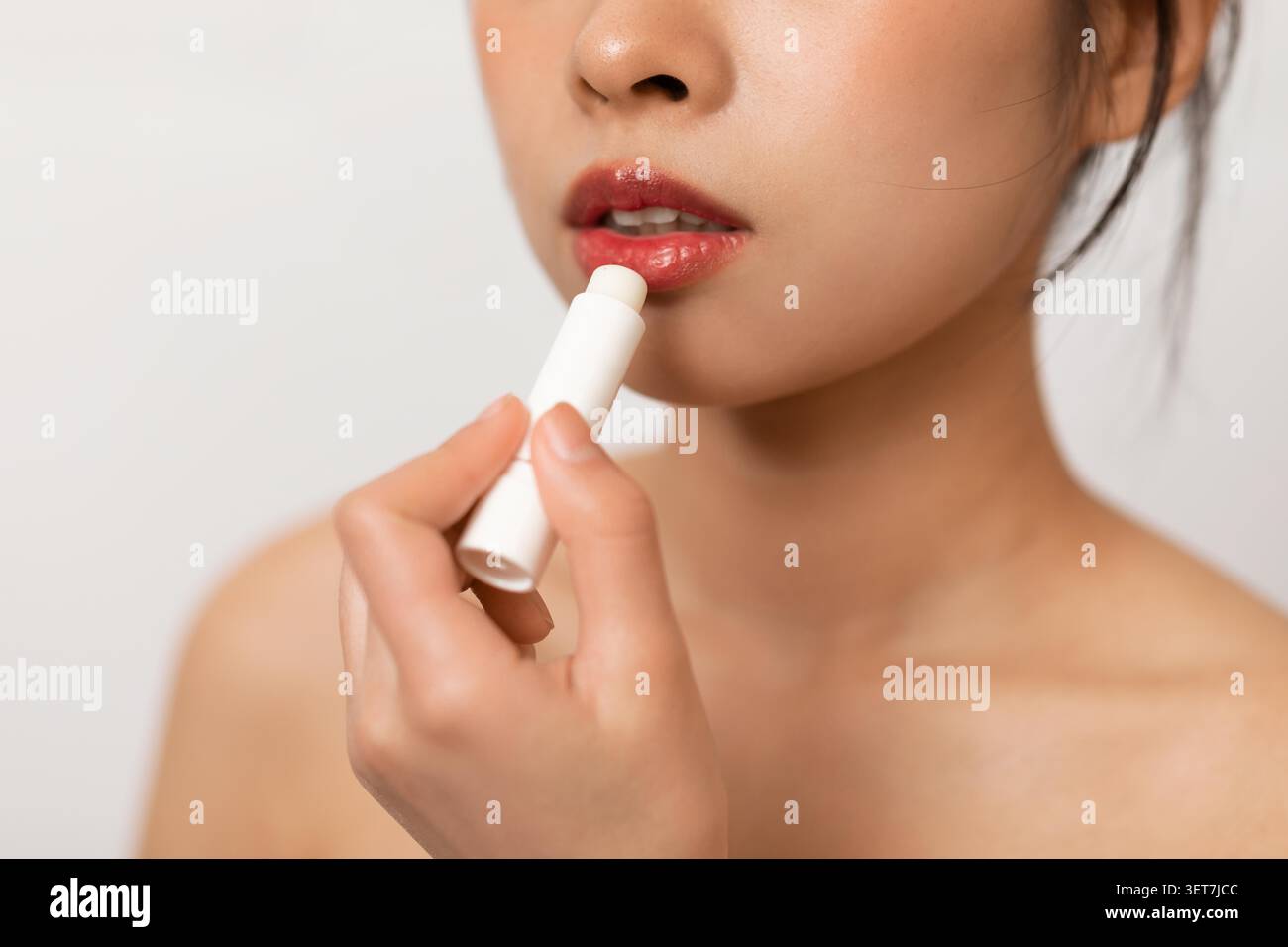 Young Asian Woman Applying Lip Balm, Close Up, Beauty Routine At Home Stock Photo