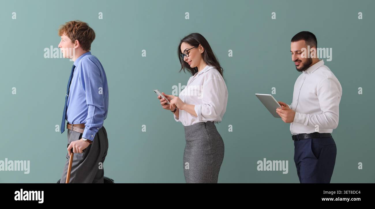 Diverse business people social distancing in line, using digital devices, modern communication and technology Stock Photo