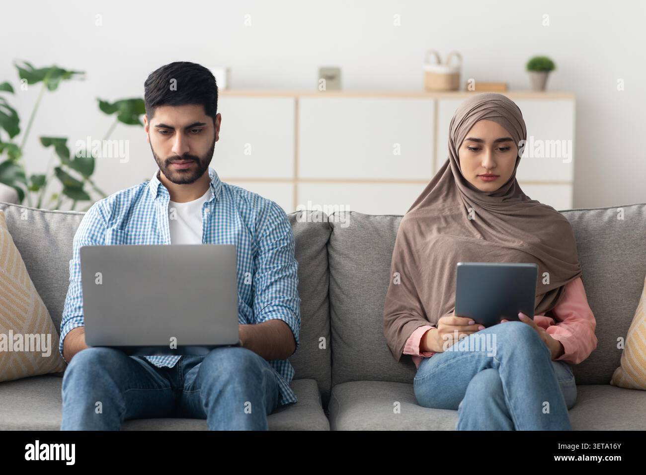 Focused Male And Female Using Laptop And Tablet For Work At Home, Business Concept Stock Photo