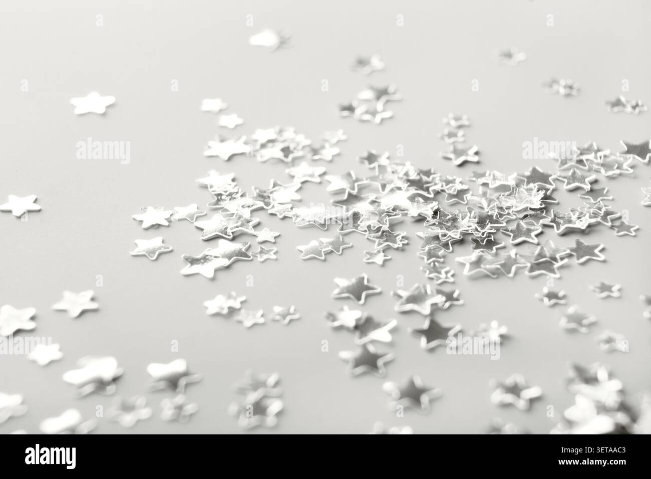 Silver star shaped confetti that creates a festive backdrop â€œColor of the Yearâ€ concept Stock Photo