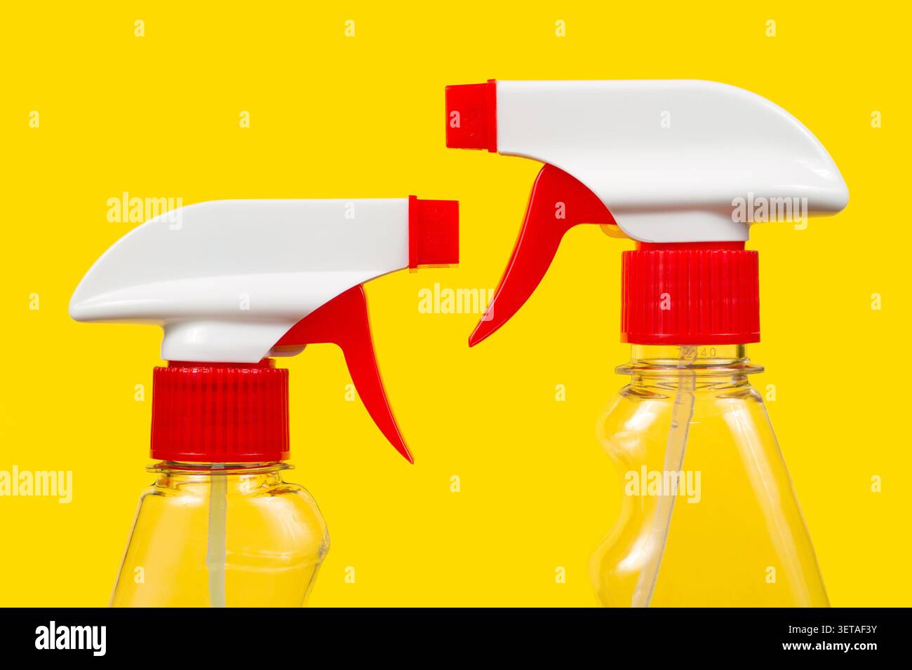 Detergent sprayers on a yellow background. Two sprayers. Stock Photo