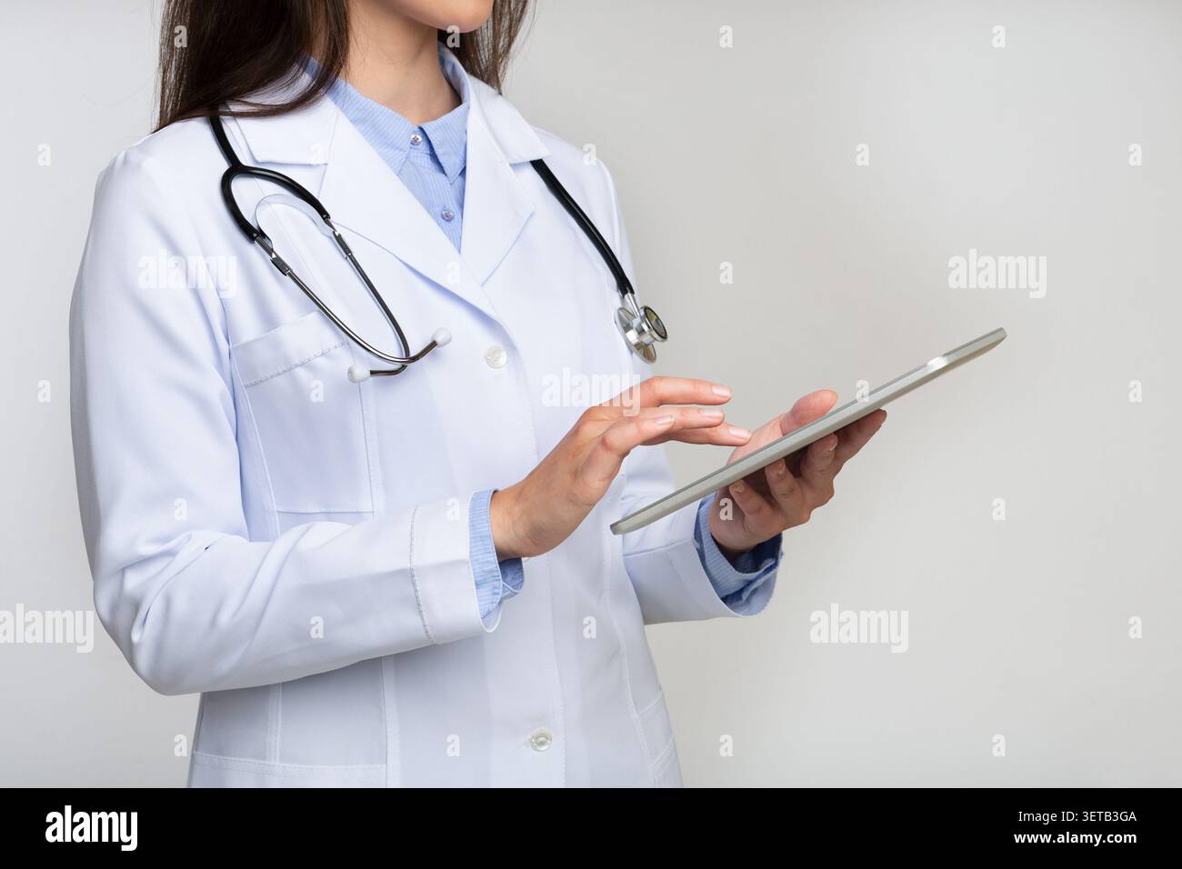 Unrecognizable Doctor Using Digital Tablet On White Stock Photo